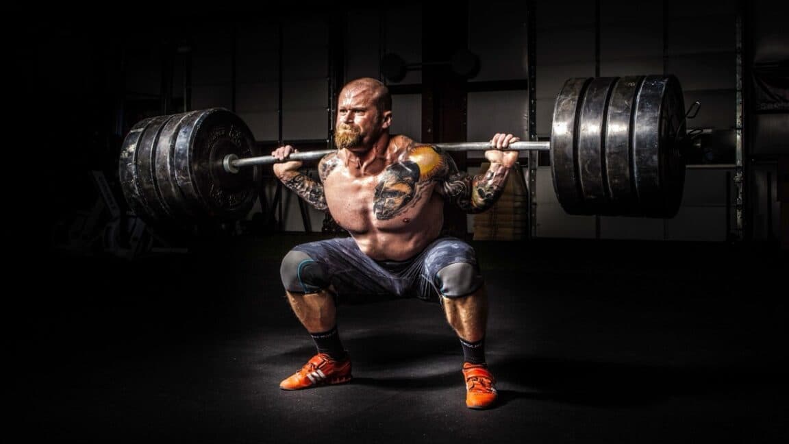 The physics of how Olympic weightlifters exploit barbell's "whip"